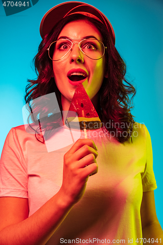 Image of Happy young woman standing and smiling against blue background