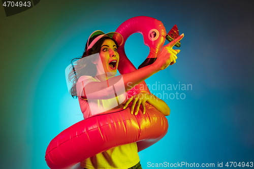 Image of Happy young woman standing and smiling against blue background