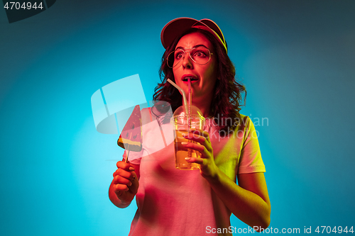 Image of Happy young woman standing and smiling against blue background