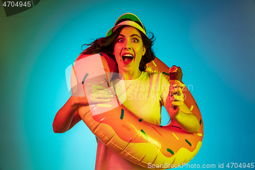 Image of Happy young woman standing and smiling against blue background