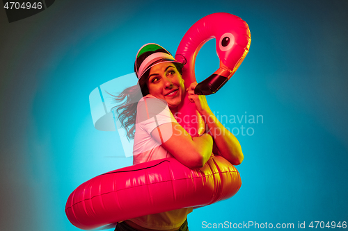 Image of Happy young woman standing and smiling against blue background