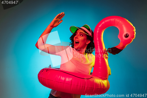 Image of Happy young woman standing and smiling against blue background