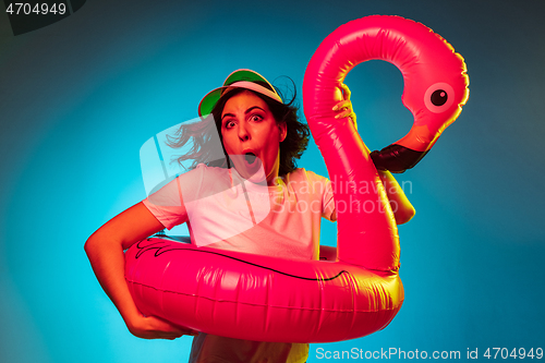 Image of Happy young woman standing and smiling against blue background