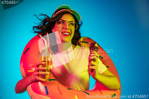 Image of Happy young woman standing and smiling against blue background