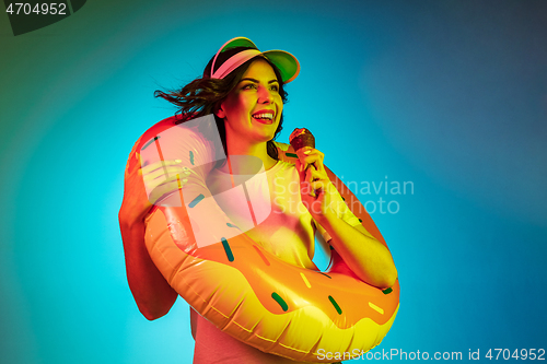 Image of Happy young woman standing and smiling against blue background