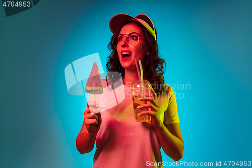 Image of Happy young woman standing and smiling against blue background