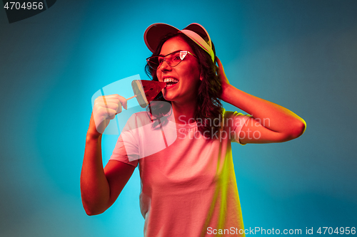 Image of Happy young woman standing and smiling against blue background