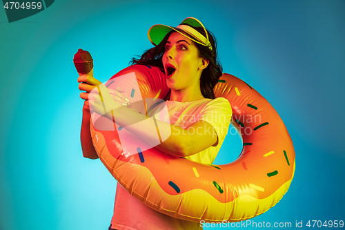 Image of Happy young woman standing and smiling against blue background