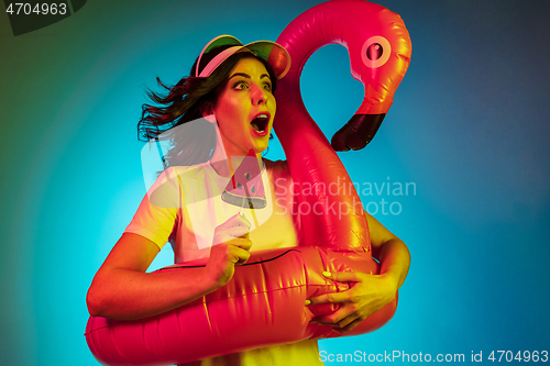 Image of Happy young woman standing and smiling against blue background