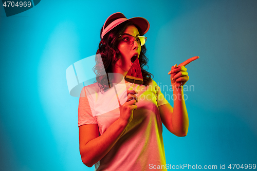 Image of Happy young woman standing and smiling against blue background