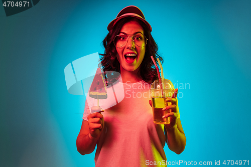 Image of Happy young woman standing and smiling against blue background