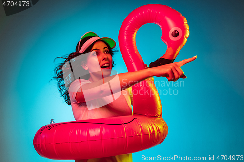 Image of Happy young woman standing and smiling against blue background