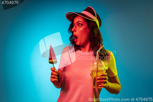 Image of Happy young woman standing and smiling against blue background