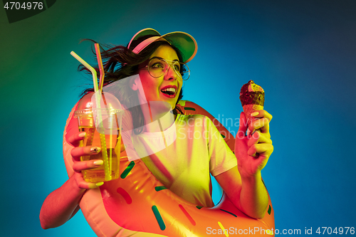 Image of Happy young woman standing and smiling against blue background