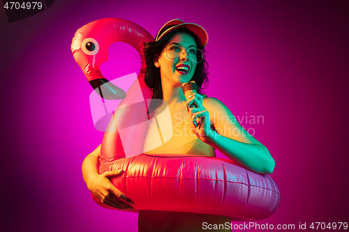 Image of Happy young woman standing and smiling against pink background