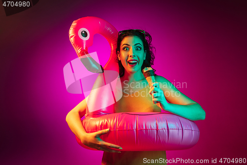 Image of Happy young woman standing and smiling against pink background