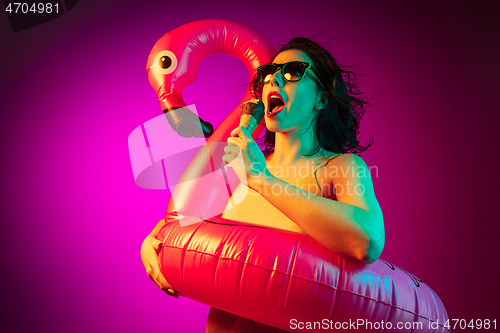 Image of Happy young woman standing and smiling against pink background