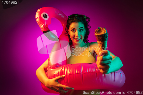 Image of Happy young woman standing and smiling against pink background