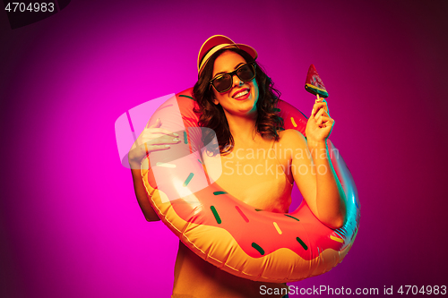 Image of Happy young woman standing and smiling against pink background