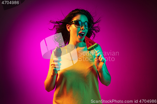 Image of Happy young woman standing and smiling against pink background