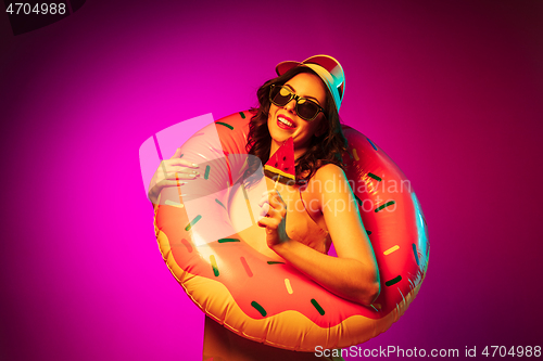 Image of Happy young woman standing and smiling against pink background