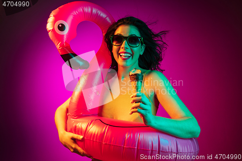 Image of Happy young woman standing and smiling against pink background