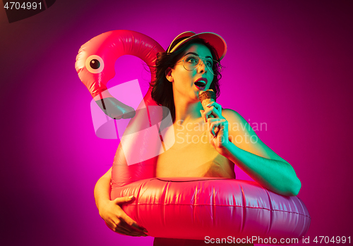 Image of Happy young woman standing and smiling against pink background