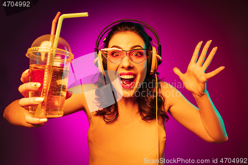 Image of Happy young woman standing and smiling against pink background