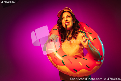 Image of Happy young woman standing and smiling against pink background