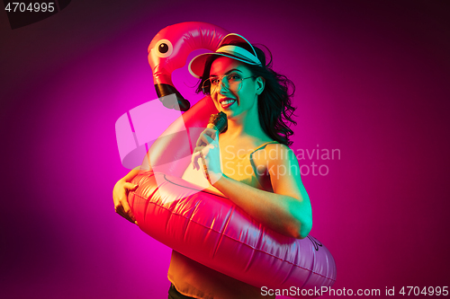 Image of Happy young woman standing and smiling against pink background