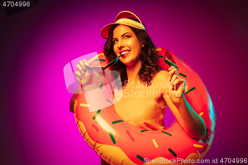 Image of Happy young woman standing and smiling against pink background