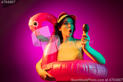 Image of Happy young woman standing and smiling against pink background