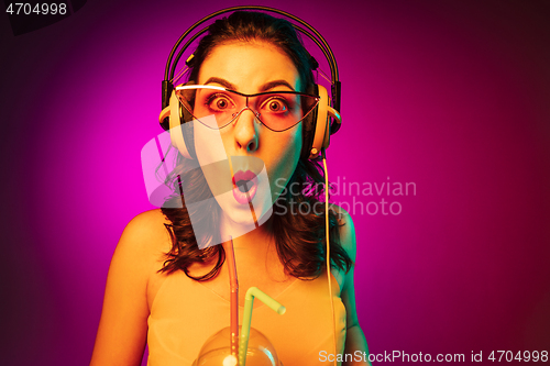 Image of Happy young woman standing and smiling against pink background