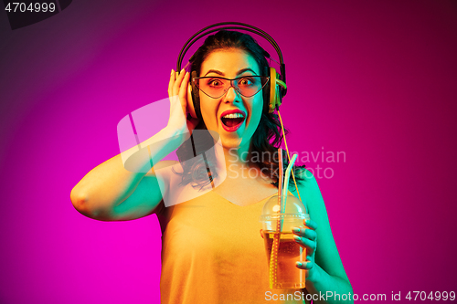 Image of Happy young woman standing and smiling against pink background