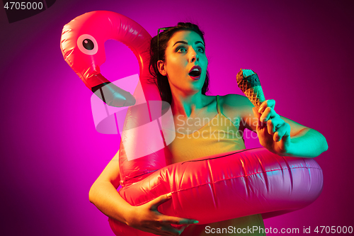 Image of Happy young woman standing and smiling against pink background