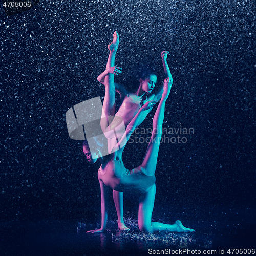 Image of Two young female ballet dancers under water drops