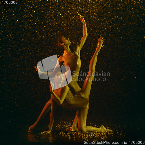 Image of Two young female ballet dancers under water drops