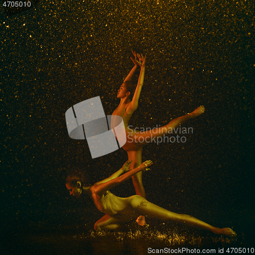 Image of Two young female ballet dancers under water drops