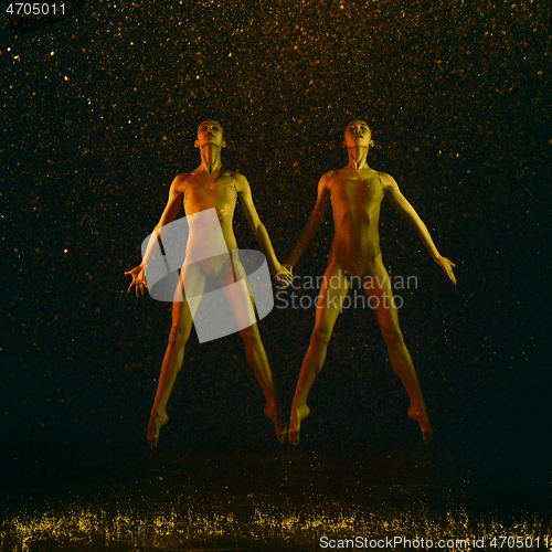 Image of Two young female ballet dancers under water drops