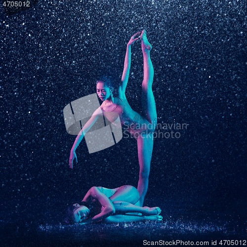 Image of Two young female ballet dancers under water drops