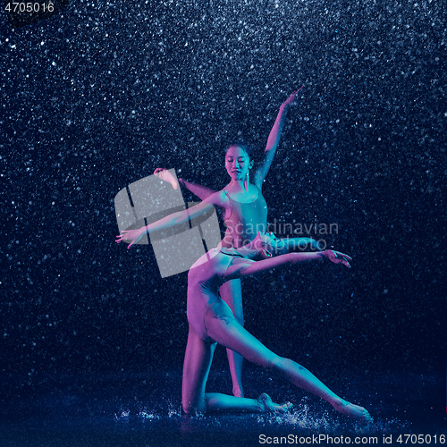 Image of Two young female ballet dancers under water drops