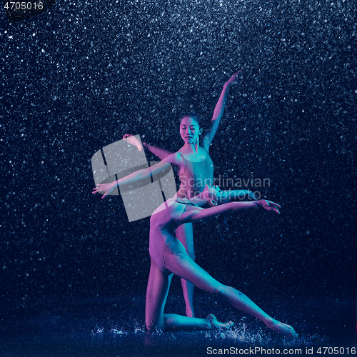 Image of Two young female ballet dancers under water drops