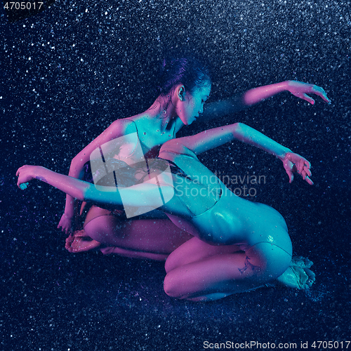 Image of Two young female ballet dancers under water drops