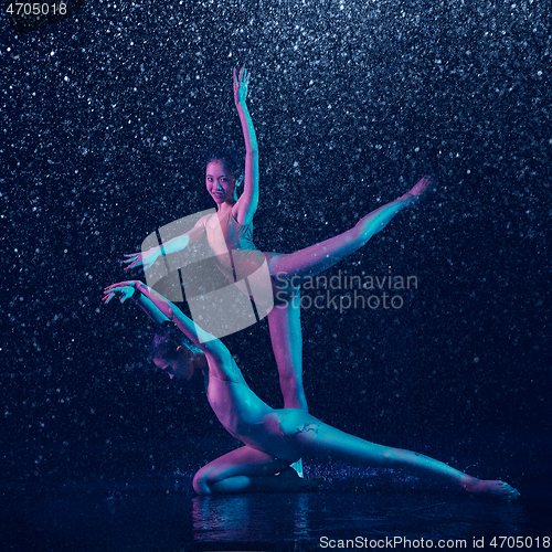 Image of Two young female ballet dancers under water drops