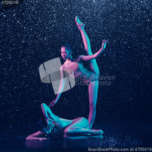 Image of Two young female ballet dancers under water drops