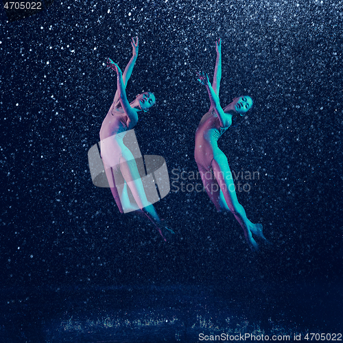 Image of Two young female ballet dancers under water drops