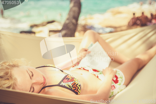 Image of Lady napping on hammock at the beach.