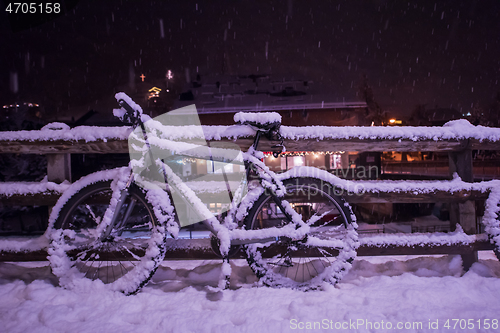 Image of parked bicycle covered by snow