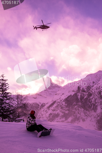 Image of rescue team with a red helicopter rescuing a hurt skier