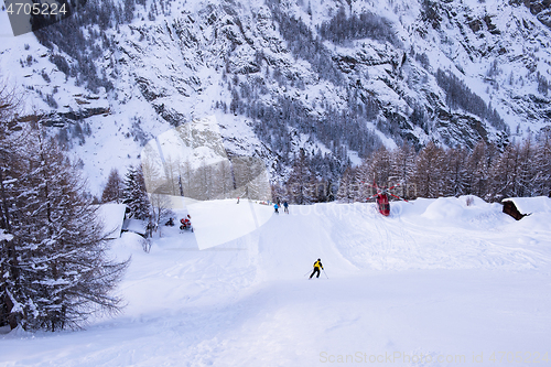 Image of rescue team with a red helicopter rescuing a hurt skier